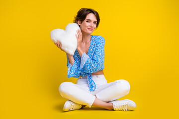 Full length photo of adorable pretty girl dressed print blouse sit holding fluffy heart shape...