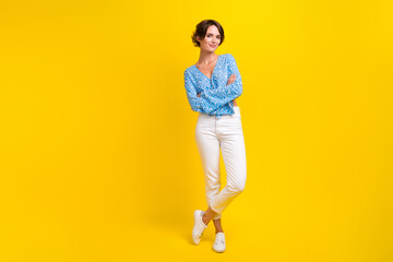 Full length photo of cool optimistic woman dressed print blouse white trousers standing arms...