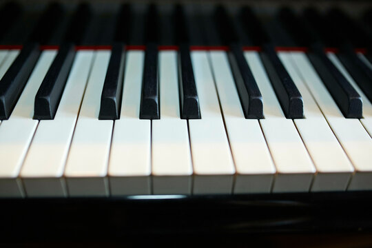 A close-up view of black and white piano keys showing their pattern and symmetry.