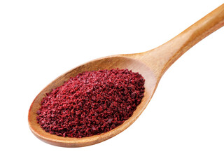 Sumac spice in a wooden spoon close-up on a white. Isolated