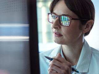 Genomics, Scientist viewing human DNA profiles on screen during testing in the lab