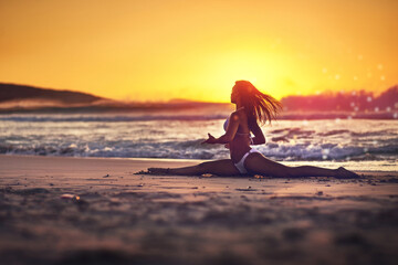 Woman, stretching and splits on beach sunset, yoga and pilates exercise for energy in nature with...