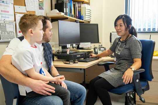 Doctor consulting with a patient in an office, father and child