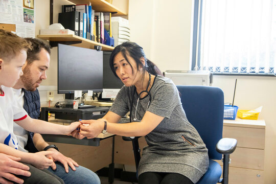 Doctor consulting with a patient in an office, father and child