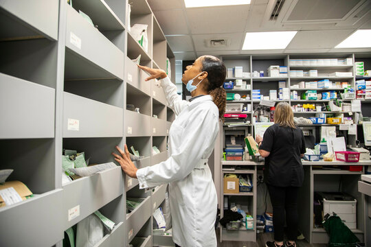 Pharmacists working in a medication storage room in a medical practice, UK