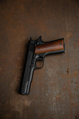 Black semi-automatic pistol with a wooden handle. Short-barreled rifled weapon. Rusty metal back