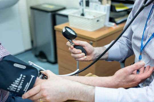 Doctor taking blood pressure reading for a patient.