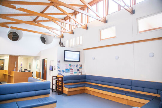 Modern waiting area with comfortable seating and informational displays in a hospital, UK.