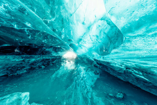 Sunlight filtering through a translucent blue ice cave.