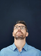 Thinking, businessman and looking up in studio for startup company, career and mockup space. Glasses, corporate male person and accountant with idea, choice and solution for job by dark background