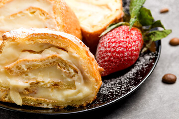 Sliced rolls with custard. The dessert is decorated with fresh strawberries