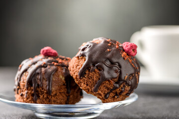 Round chocolate cakes. Decorated with candied raspberries. Dark background