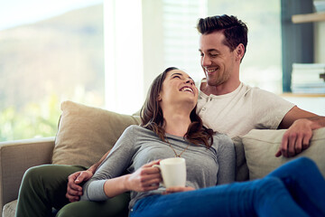 Couple, drinking coffee and laugh in home living room, talking or bonding together to relax. Tea...