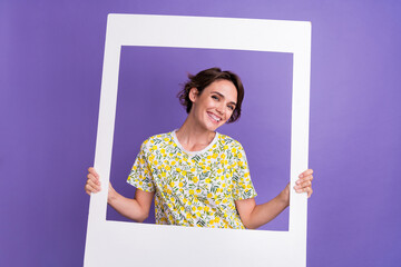 Photo of pretty young woman hold album set card wear t-shirt isolated on violet color background