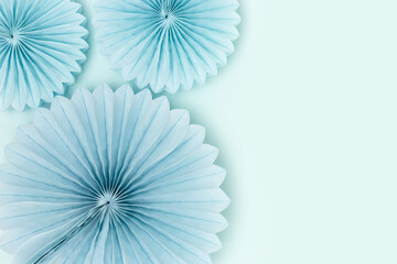 Tissue paper fans on a blue background. Monochrome concept with copy space.