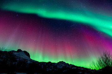 Polar lights, Aurora borealis in green & red & purple over mountains, Norway