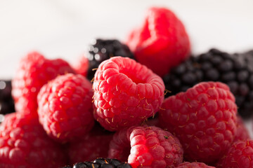 Handful of raspberry and blackberry berries on white background