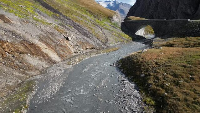 Flight along river bed under bridge Val D'isere