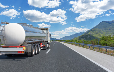 Fuel truck on a picturesque road. A silver tank truck transports fuel.