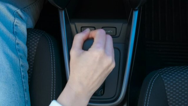 Lady start driving trip in auto gear car. A view of female sitting by the wheel and start driving and change the auto gear.