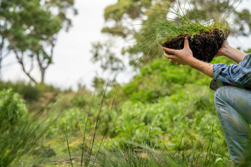 farmer wearing blue shirt and jeans, farmer holding soil, doing soil tests in a home laboratory. Looking at soil life and health