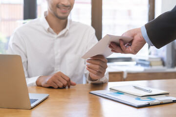 Good job Asian manager business man giving financial reward in an envelope, business letter extra salary to company employee, male worker office hand received premium bonus, getting cheque from boss.