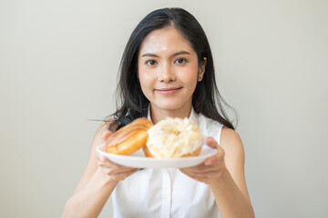 Portrait of happy smile asian young woman, girl temptation food, holding donut plate, enjoy eating sugar glazed doughnut delicious dessert sweet, snack tasty. Eat fast food, junk food meal getting fat