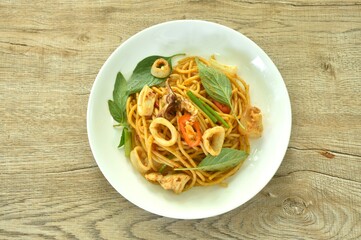 spicy stir fried spaghetti slice squid with chili and basil leaf in sauce on plate 