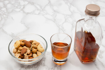 大理石の上にウィスキーミニボトルとショットグラスとおつまみ