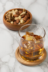 角氷のウィスキーロックとナッツのおつまみ
