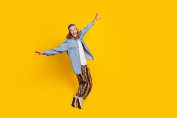 Full body portrait of cool young man dancing empty space wear denim shirt isolated on yellow color...