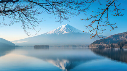 Crisp winter morning by Lake Kawaguchi, featuring Mount Fuji's snow-capped summit, calm waters, and bare tree branches adding a touch of seasonal charm.