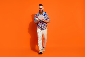 Full size photo of brutal man with red long beard wear stylish shirt look at tablet go to work...