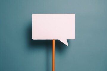 Minimalist white speech bubble on orange stick against muted blue background, modern touch