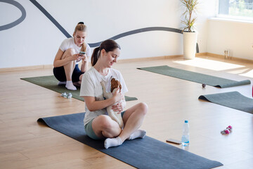 happy girl doing yoga with little Jack Russell terrier puppy. Healthy lifestyle and meditation
