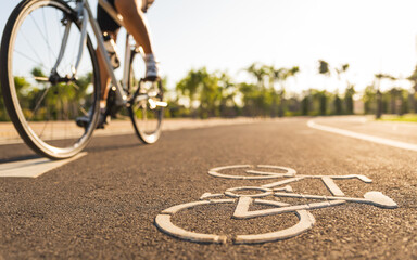 Close up cycling logo image on road with athletic women cyclist legs riding Mountain Bike in...