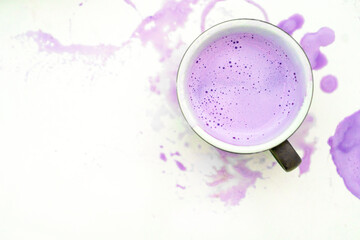 Top View of a Cup with Purple Latte on White Background with Spilled Drink