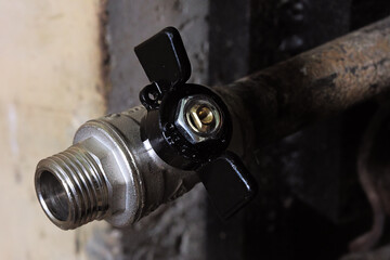 A Black And Silver Valve With A Gold Nut On Top