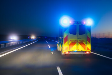 Fast moving ambulance car of emergency medical service on highway at night. Themes healthcare,...
