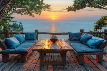 Obraz premium Luxurious outdoor deck with ocean view at sunset, featuring cozy seating and rustic decor for a serene and inviting space perfect for relaxation