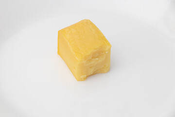 Grilled tofu in white dish on white background. Chickpea tofu.