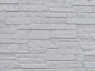 Fototapeta premium Uneven stones or bricks as a background and texture. Background, texture, pattern, frame, copy space. Close-up view of a wall with uneven stone bricks