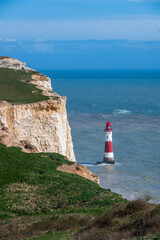 a lighthouse sits on top of a rocky cliff on the ocean