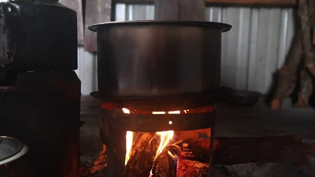 Traditional way of cooking using wood to cook food in large utensil