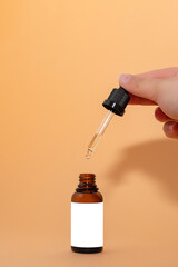 Flacon de produit cosmétique, pipette cosmétique, main avec pipette, packaging avec étiquette...