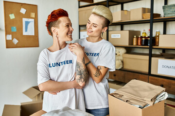 A lesbian couple in volunteer t-shirts work together in charity.