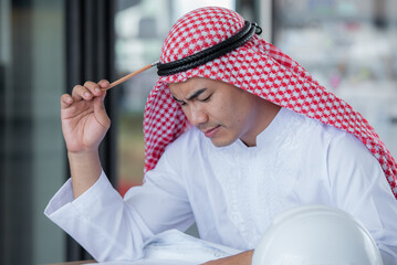 Middle Eastern businessmen in traditional clothing working on a project.