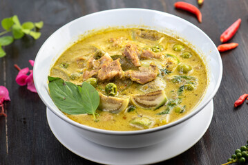 A bowl of green curry with beef