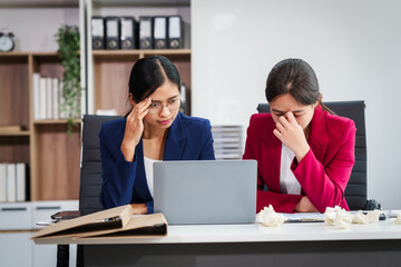 Two Asian businesswomen under stress and pressure discuss financial matters, experiencing anxiety and worry while navigating the complexities of the stock market and loan applications.