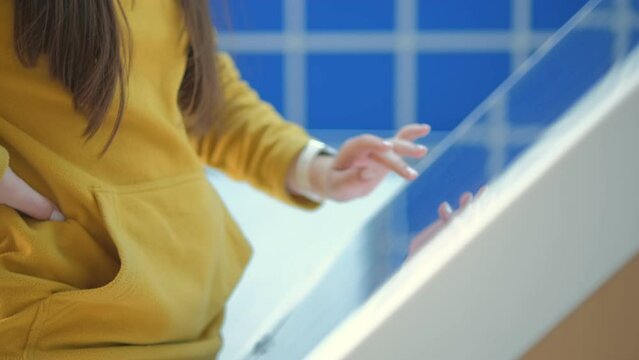 A person using a touchscreen at a modern exhibit to explore technology and digital content